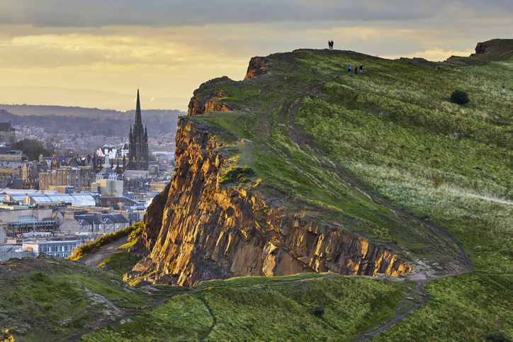 Close-up of late afternoon sunlight illuminating the cliff face. St Columba's Free Church of Scotland steeple is visible